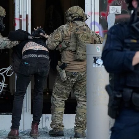 A person is arrested in Portland by heavily armed ICE officers dressed in army fatigues.